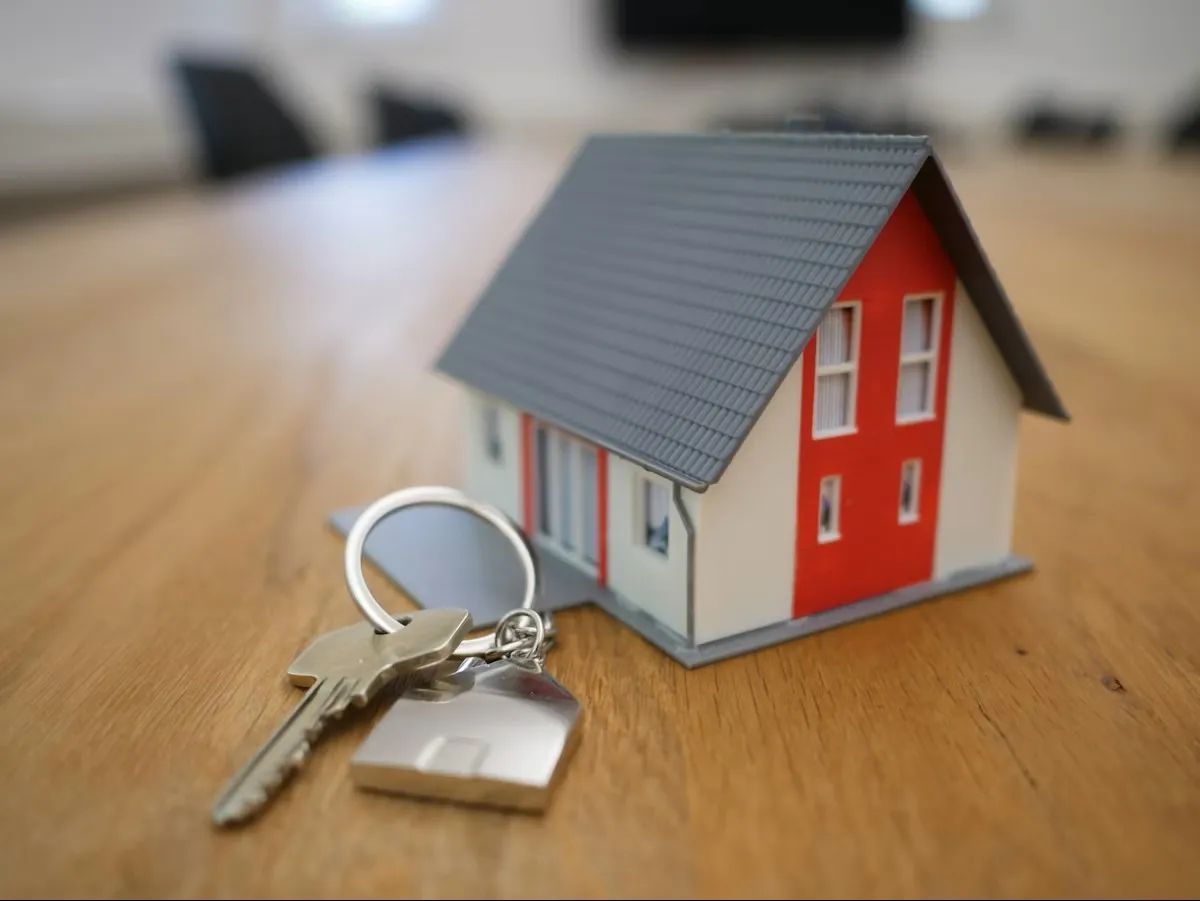 Homebuyers holding keys in front of a home
