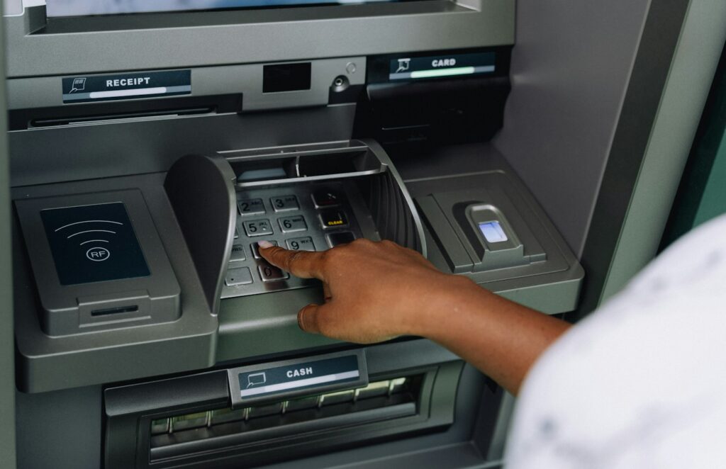 Person using an ATM – banking mistakes before applying for a mortgage