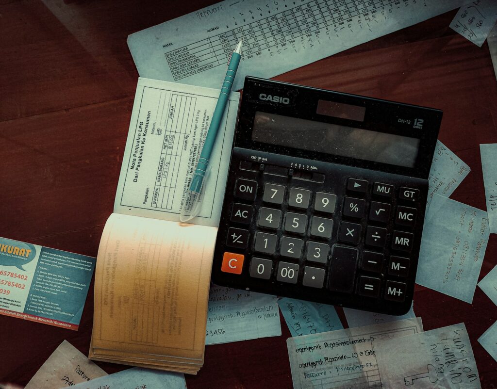 Calculator on a wooden table – buying a house with collections
