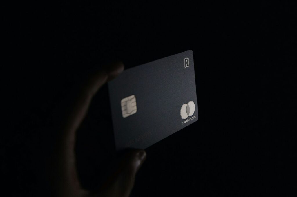 Person holding a black credit card – opening new credit before closing